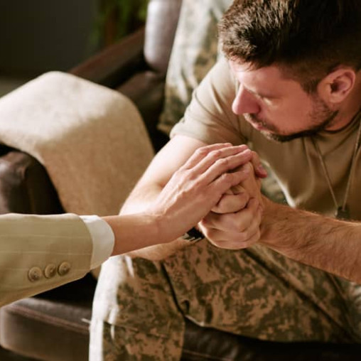 An army solider being consoled by a professional.